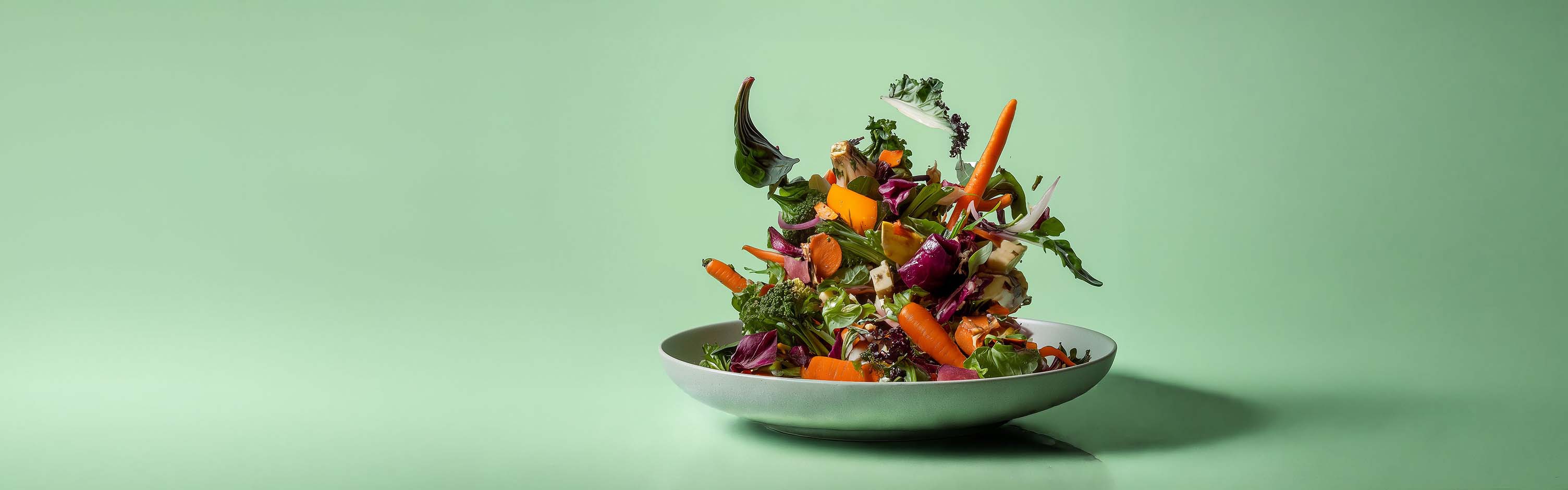 Plate with vegetables falling onto it