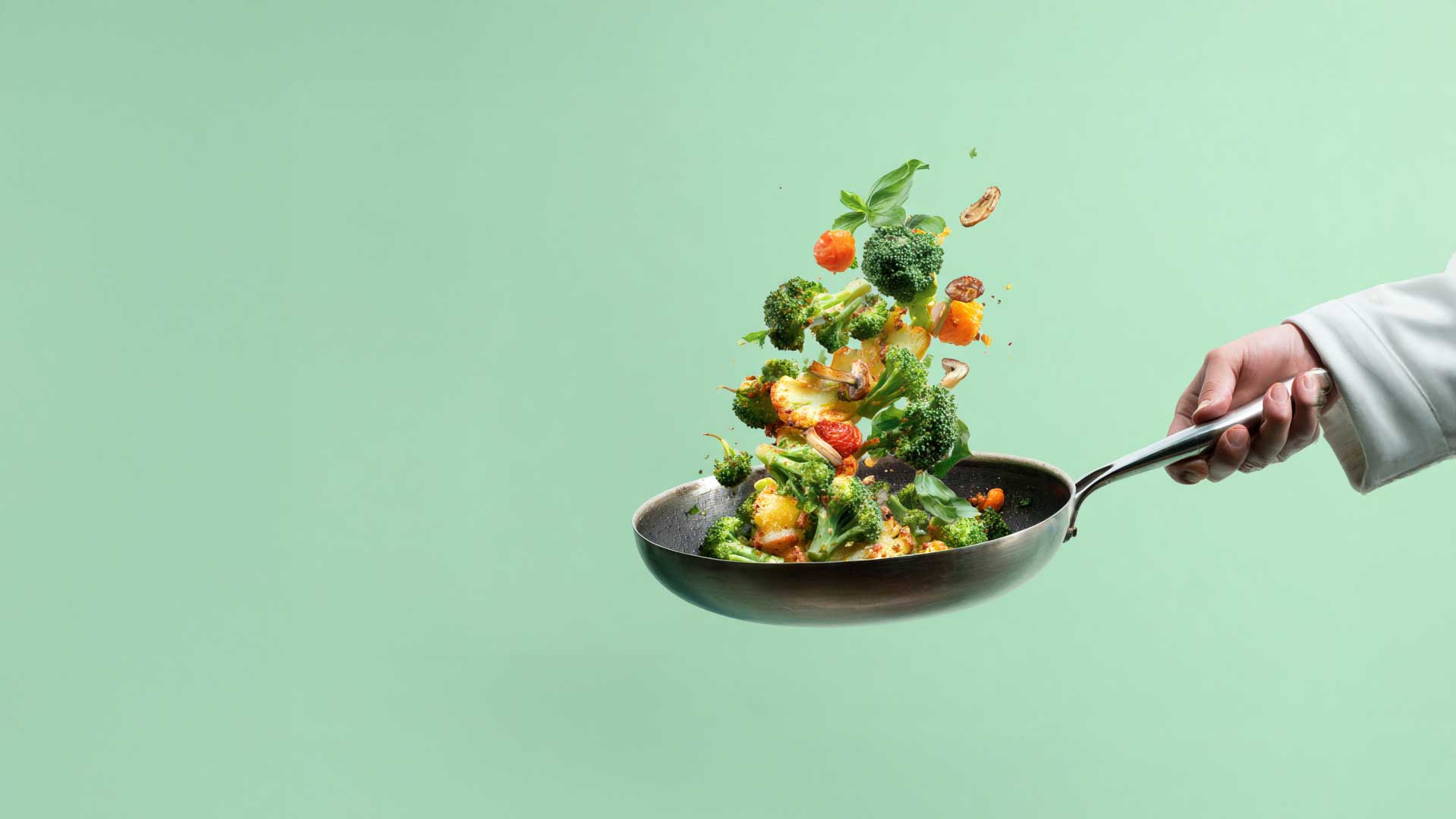 Vegetables being tossed in saute pan
