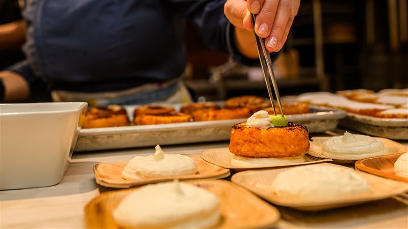 Chef using tweezers to plate an appetizer