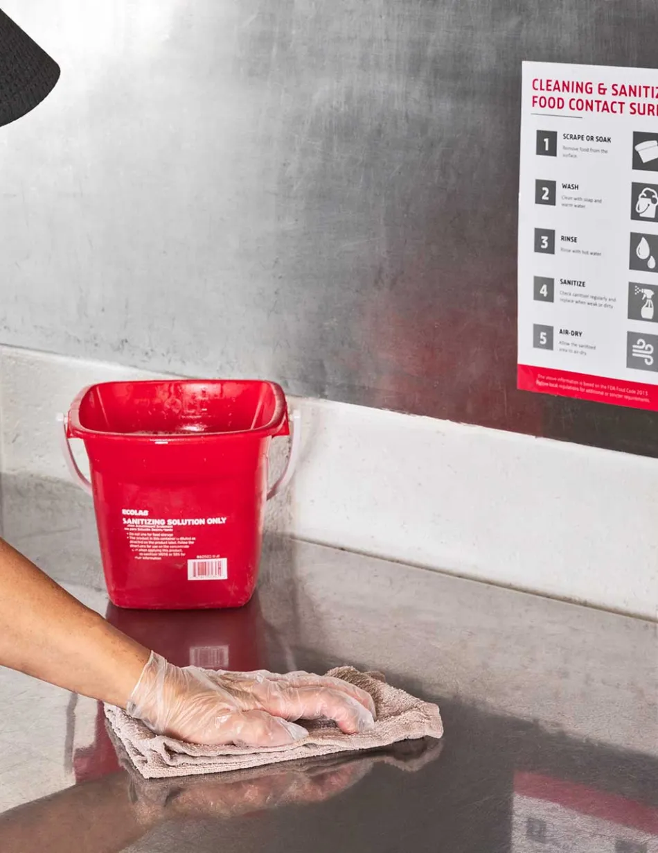 Employee wiping down and sanitizing surface