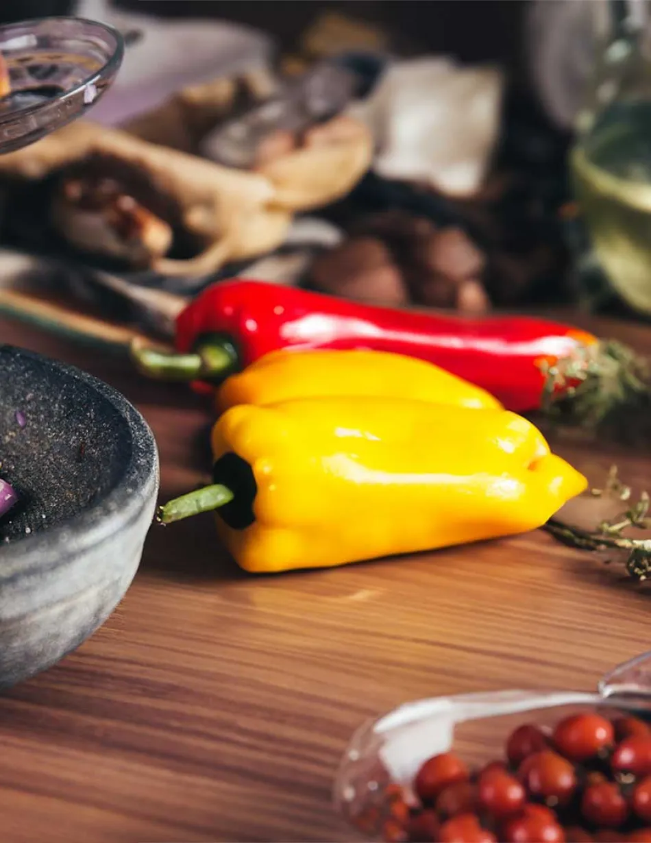 Ingredients on a wood table, handing pouring salt into a mortar