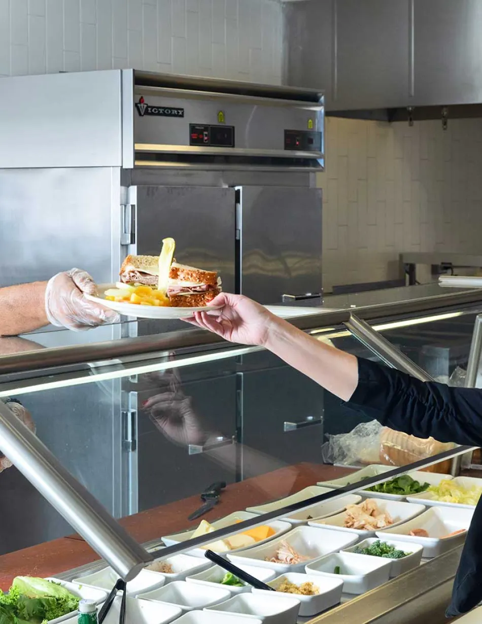 Cook passing sandwich to customer
