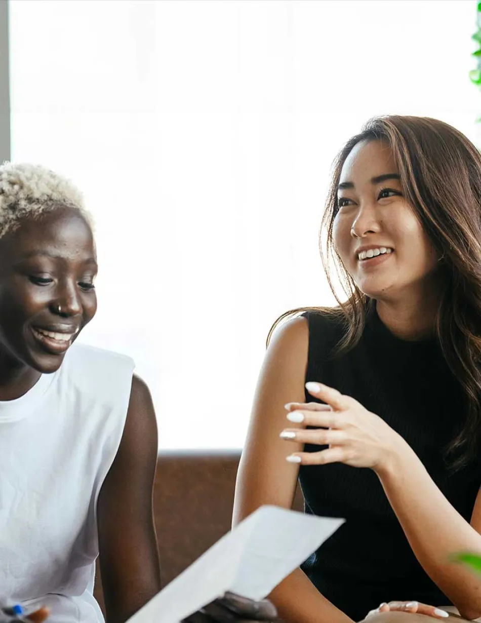 Two office employees smiling while talking