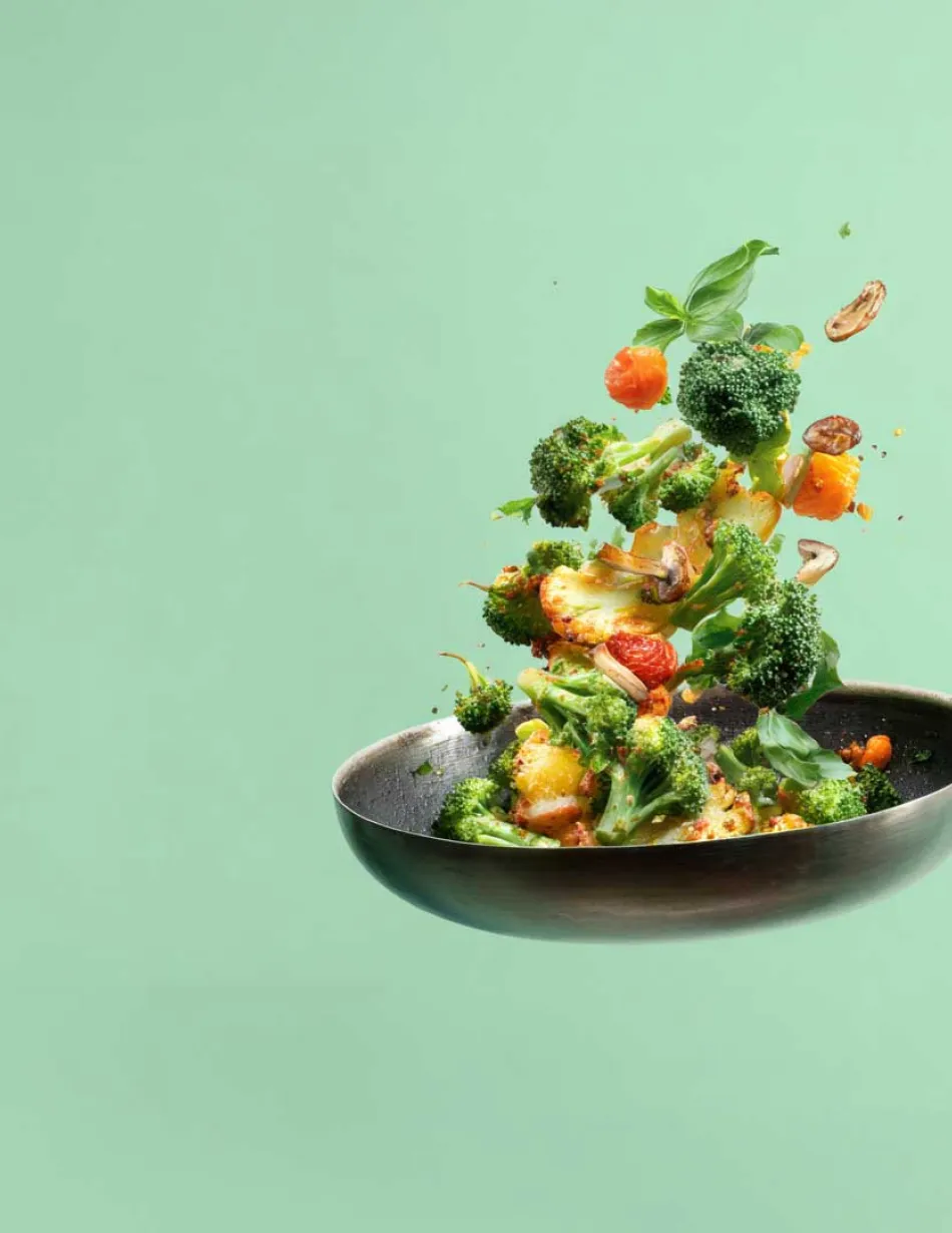 Vegetables being tossed in saute pan