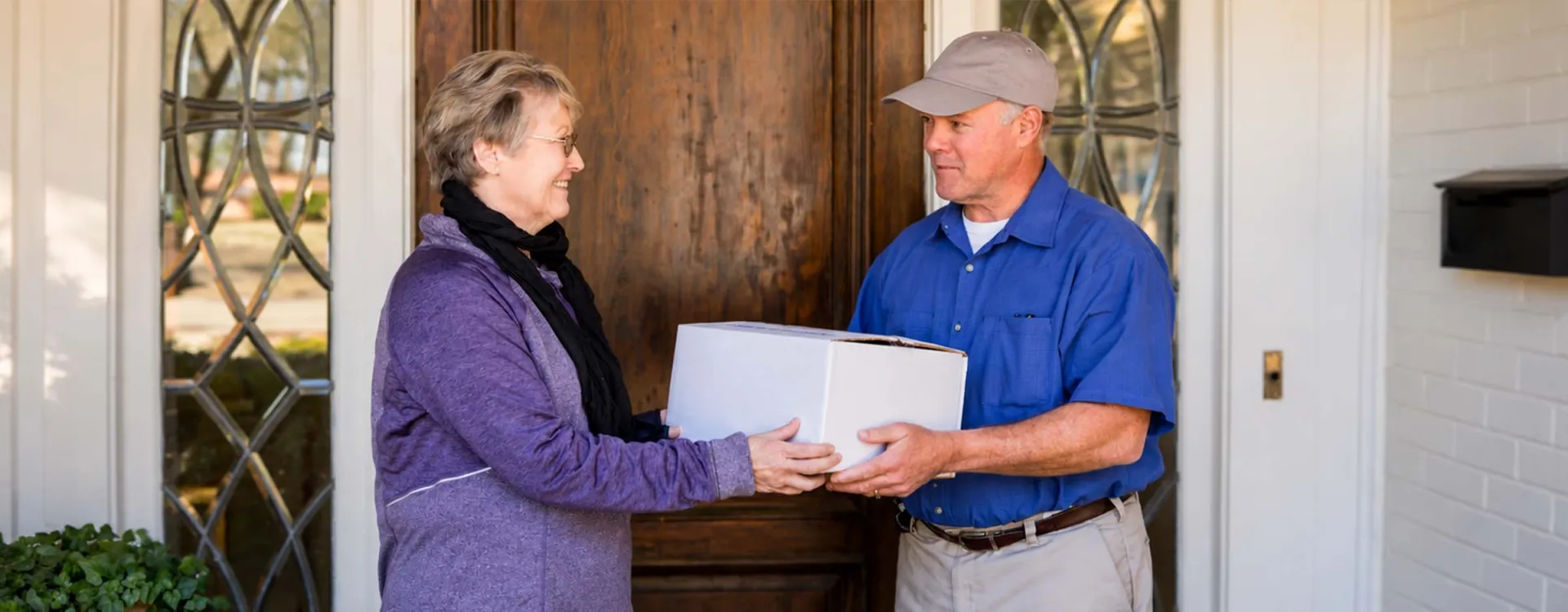 Community meal delivery driver delivering nutritious, home-delivered meals to an older adult, supporting senior health and independent living.