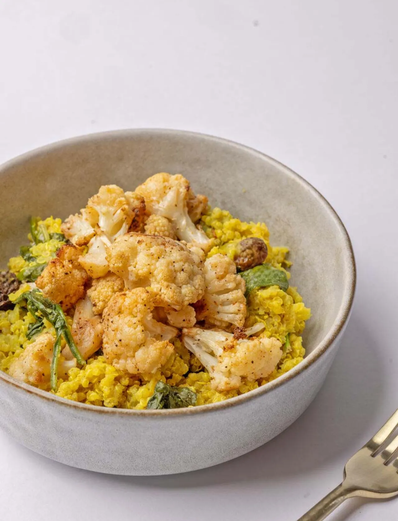 Roasted cauliflower served over yellow rice with leafy greens, showcasing fresh, wholesome ingredients and nutritious, plant-based dining through Elior North America’s BeWell program.