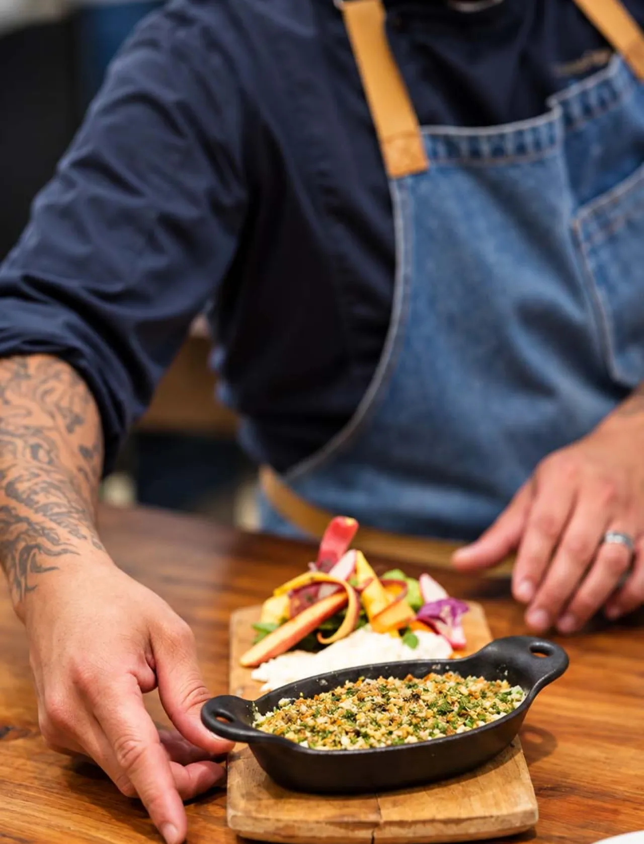Elior North America chef carefully presents a freshly prepared dish, reflecting our food philosophy of culinary innovation, quality ingredients, and thoughtful food experiences that nourish people.