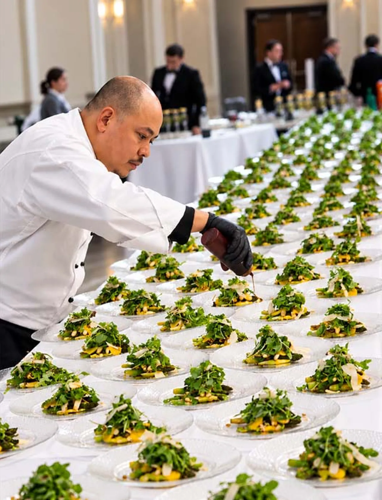Elior North America chef carefully plates fresh, chef-crafted meals for a catered event, showcasing culinary expertise, personalized service and attention to detail.