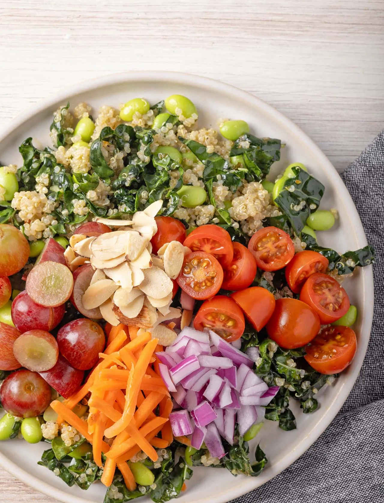 Colorful plant-forward salad featuring quinoa, kale, edamame, cherry tomatoes, carrots, grapes, and almonds, showcasing Elior North America’s commitment to nutritious, sustainable, plant-based dining.